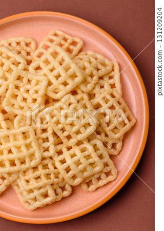 Lattice or wafer potato chips, crispy yellow snacks, takeaway food Lattice or wafer potato chips, crispy yellow snacks, takeaway food 131209204