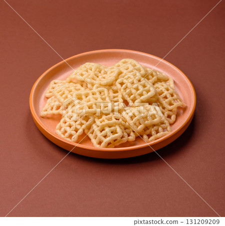 Lattice or wafer potato chips, crispy yellow snacks, takeaway food Lattice or wafer potato chips, crispy yellow snacks, takeaway food 131209209