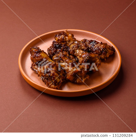 Grilled or barbecued chicken wings with teriyaki sauce, spices and sesame seeds. Teriyaki chicken Grilled or barbecued chicken wings with teriyaki sauce, spices and sesame seeds. Teriyaki chicken 131209284
