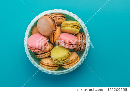 Different flavors of macarons. Colourful macaroons in bowl on blue background. Top view. 131209366