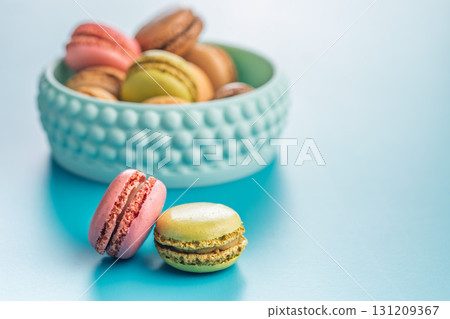 Different flavors of macarons. Colourful macaroons on blue background. 131209367