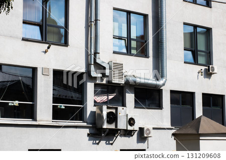 A large building that features numerous windows and air conditioning units 131209608