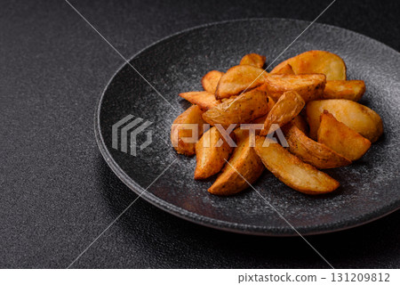 Grilled potato wedges with rosemary, cheese, salt and spices. Baked potato slices Grilled potato wedges with rosemary, cheese, salt and spices. Baked potato slices 131209812