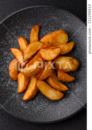Grilled potato wedges with rosemary, cheese, salt and spices. Baked potato slices Grilled potato wedges with rosemary, cheese, salt and spices. Baked potato slices 131209814