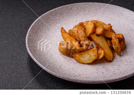Grilled potato wedges with rosemary, cheese, salt and spices. Baked potato slices 131209839