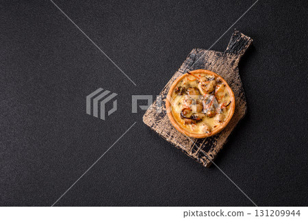 Pie or quiche, a sour tart with chicken and mushrooms, spices and herbs. Round quiche with chicken 131209944