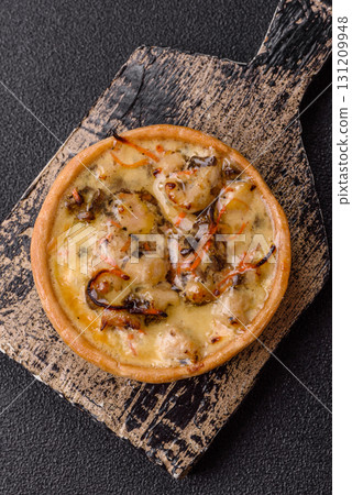 Pie or quiche, a sour tart with chicken and mushrooms, spices and herbs. Round quiche with chicken Pie or quiche, a sour tart with chicken and mushrooms, spices and herbs. Round quiche with chicken 131209948
