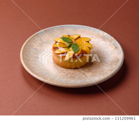 Sweet round pie or tart with apples and peach. Mini sweet tart 131209961