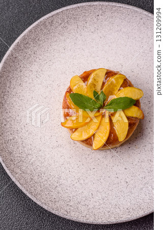 Sweet round pie or tart with apples and peach. Mini sweet tart 131209994