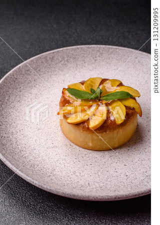 Sweet round pie or tart with apples and peach. Mini sweet tart 131209995