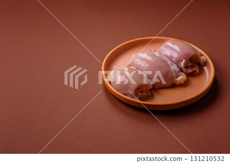 Raw chicken thigh fillet without skin and bone with salt and spices. Raw chicken fillet for cooking Raw chicken thigh fillet without skin and bone with salt and spices. Raw chicken fillet for cooking 131210532