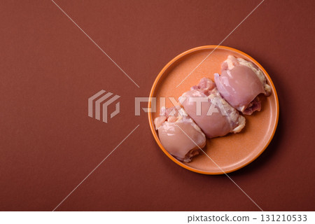 Raw chicken thigh fillet without skin and bone with salt and spices. Raw chicken fillet for cooking Raw chicken thigh fillet without skin and bone with salt and spices. Raw chicken fillet for cooking 131210533