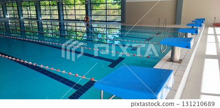 A modern indoor pool with marked lanes and starting blocks. Ideal for sports training, fitness, and swimming competitions. 131210689
