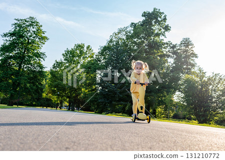Girl on scooter. Riding child outdoor fun. Sunshine road freedom lifestyle. Girl on scooter. Riding child outdoor fun. Sunshine road freedom lifestyle. 131210772
