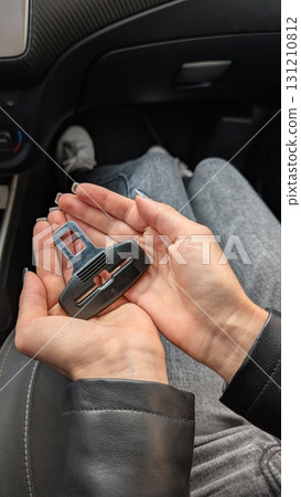 A car seatbelt buckle held in hand while inside the vehicle during a drive experience A car seatbelt buckle held in hand while inside the vehicle during a drive experience 131210812