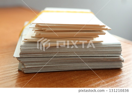 A Stack of Various Important Documents Neatly Organized and Arranged on a Wooden Table Surface 131210836