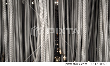 In this closeup image, we see intricate industrial cables and hoses set against a dark environment In this closeup image, we see intricate industrial cables and hoses set against a dark environment 131210925