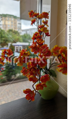 A beautiful arrangement of vibrant faux flowers elegantly displayed in a decorative vase A beautiful arrangement of vibrant faux flowers elegantly displayed in a decorative vase 131210946