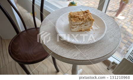 A Delicious and Tempting Cake Slice Displayed on a Beautiful Wooden Table Surface 131210968