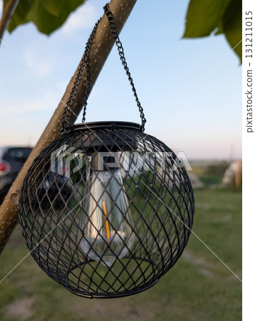 A beautifully designed hanging lantern creates a charming ambiance in a rustic outdoor setting A beautifully designed hanging lantern creates a charming ambiance in a rustic outdoor setting 131211015