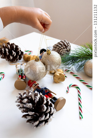 Festive holiday decorations with silver ornaments and pinecones on a white table 131211132