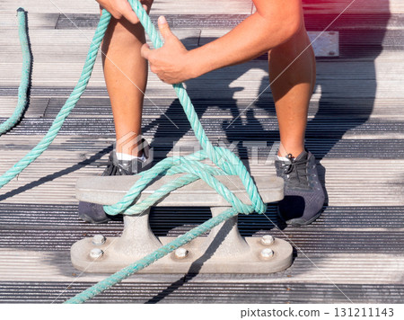 Person secures a boat rope to the dock. 131211143