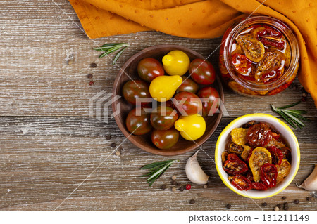 Flatlay of dried cherry tomatoes in a jar and plate with ingredients. 131211149