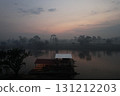 Early morning mist rising over the river with a wooden structure nearby 131212203