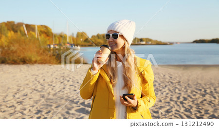 Stylish happy woman standing on beach, girl smiles, looking away on sea 131212490