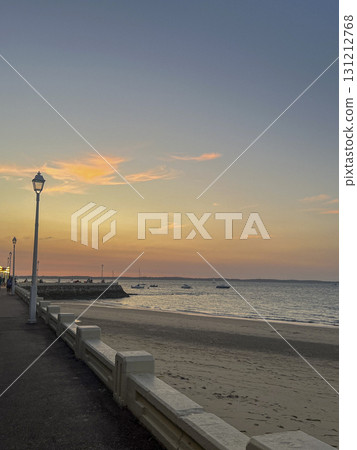 Sunset view over the calm waters of Arcachon bay with sandy shoreline 131212768