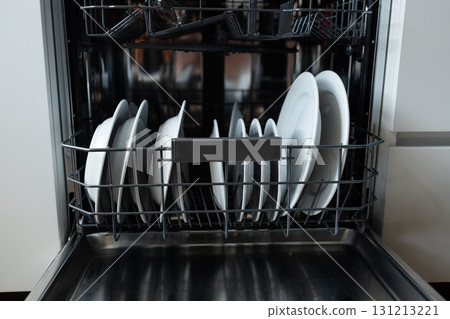 Open dishwasher with clean white plates inside 131213221