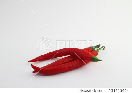 Chili peppers on a white background. Fresh chili pepper close up. One red pepper on a white Chili peppers on a white background. Fresh chili pepper close up. One red pepper on a white 131213604
