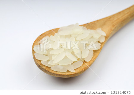 Raw white rice on wooden background. Long uncooked rice in wooden plate. Natural organic food. Traditional Asian cereal culture. 131214075