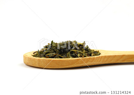 Green tea with herbs in wooden spoons on a White Background. 131214324
