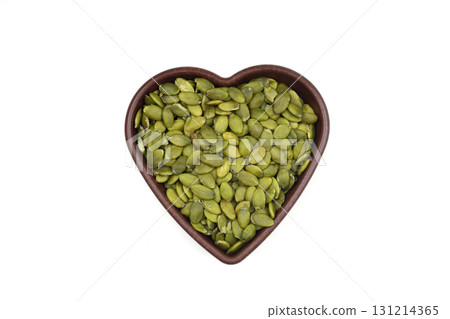 Pumpkin seeds in a wooden bowl on a white background Pumpkin seeds in a wooden bowl on a white background 131214365
