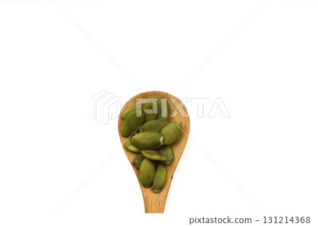 Pumpkin seeds in a wooden spoon on a white background 131214368