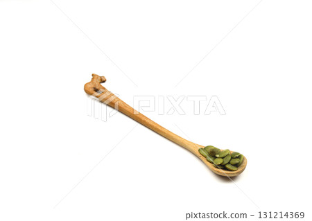 Pumpkin seeds in a wooden spoon on a white background Pumpkin seeds in a wooden spoon on a white background 131214369