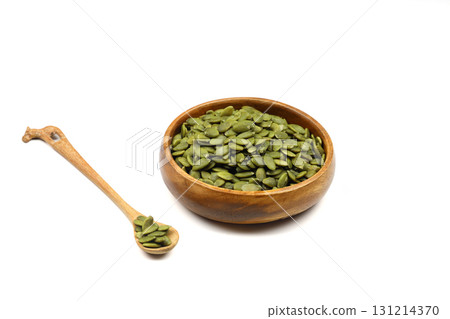 Pumpkin seeds in a wooden bowl on a white background Pumpkin seeds in a wooden bowl on a white background 131214370