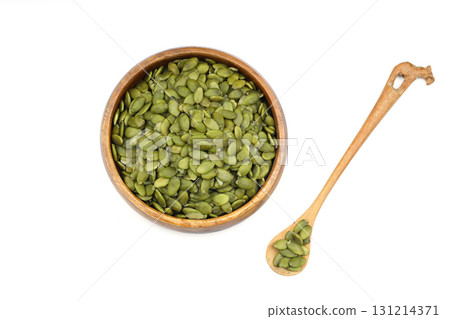Pumpkin seeds in a wooden bowl on a white background Pumpkin seeds in a wooden bowl on a white background 131214371