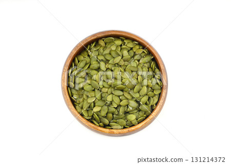 Pumpkin seeds in a wooden bowl on a white background Pumpkin seeds in a wooden bowl on a white background 131214372