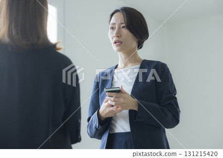 操縱智能手機的衣服的一名婦女 131215420