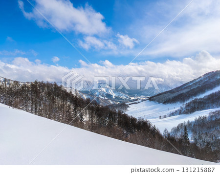 Overlooking the slopes and mountains covered in fresh snow from a high vantage point (Maiko, Minamiuonuma City, Niigata Prefecture) 131215887