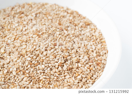 Close-up of white sesame seeds (raw sesame seeds) in a plate Close-up of white sesame seeds (raw sesame seeds) in a plate 131215992