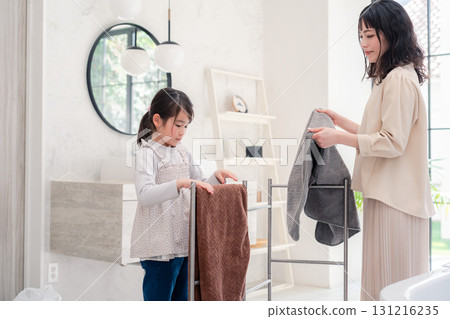 Little girl helping with laundry Little girl helping with laundry 131216235