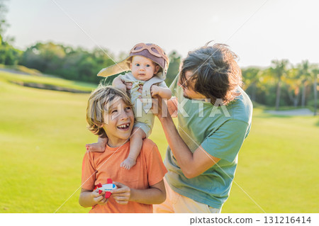Father, son, and newborn on a meadow. Baby wearing a pilot hat, symbolizing dreams of aviation. Concept of family bonding, future pilot, and childhood aspirations 131216414