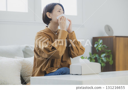 A woman with a cold wearing a mask A woman with a cold wearing a mask 131216655