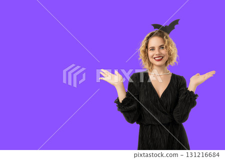 Woman with curly hair happily poses in Halloween attire Woman with curly hair happily poses in Halloween attire 131216684