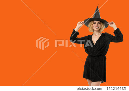 A woman enjoys Halloween festivities in a witch costume A woman enjoys Halloween festivities in a witch costume 131216685