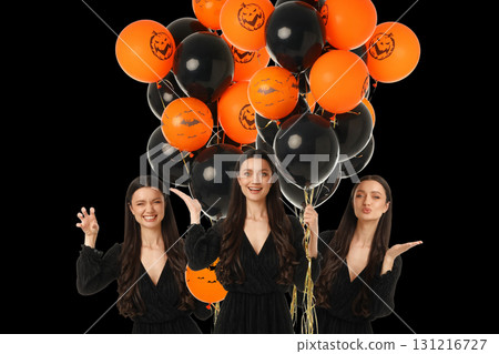 Woman dressed in black holds Halloween balloons with joy Woman dressed in black holds Halloween balloons with joy 131216727
