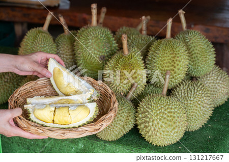 Cropped shot view of woman hands holding and showing durians before eat it. 131217667